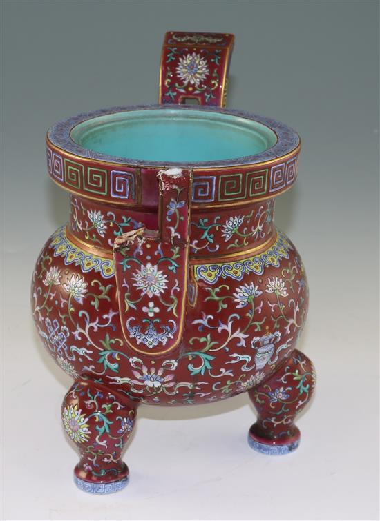 A Chinese famille rose ruby ground tripod censer, Jiaqing six character seal mark and of the period (1796-1820), height 27cm, damage an